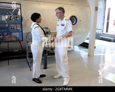 Hinterer Adm. Tim Weber, Commander, Naval Medical Forces Pacific, überreicht eine Münze an Hospital Corpsman 3rd Class Victoria Diaz, das dem Marine Submarine Medical Research Laboratory zugewiesen wurde Stockfoto