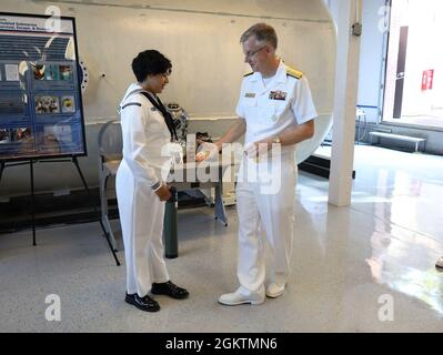 Hinterer Adm. Tim Weber, Commander, Naval Medical Forces Pacific, überreicht eine Münze an Hospital Corpsman 3rd Class Victoria Diaz, das dem Marine Submarine Medical Research Laboratory zugewiesen wurde Stockfoto