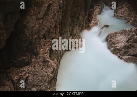 Lange Exposition von fließendem Wasser in der Leutaschschlucht. Mystischer Blick auf die felsige Umgebung mit Fluss in Tirol. Stockfoto