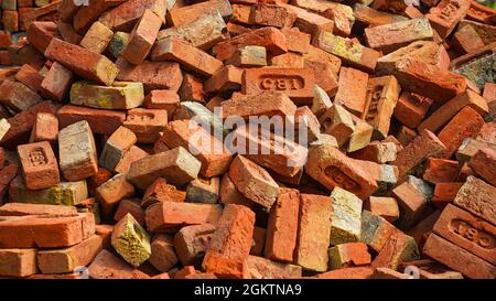 Haufen roter Steine. Traditionelle rote Steine stapeln sich in der Nähe einer Baustelle in Indien. Indien Im Ländlichen Raum Stockfoto