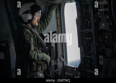 210630-N-MZ836-1307 NORFOLK, VA. Naval Air Crewman (Helikopter) Airman James Albanese, der dem Hubschrauber Mine CounterMeasures Squadron (HM) 12 zugewiesen wurde, führt während eines 9-Flugzeuge Formationsfluges Beobachteraufgaben durch. Ziel der Übung war es, die Interoperabilität der Geschwader und die taktische Bereitschaft zu erhöhen. Stockfoto