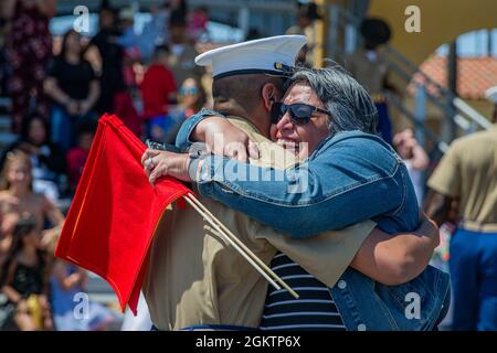 Eine neue Marine of Alpha Company, 1. Rekrut Training Bataillon, wird nach einer Abschlussfeier im Marine Corps Recruit Depot, San Diego, am 1. Juli 2021 von einem Angehörigen begrüßt. Als Rekruten waren ihre einzigen Kontaktmöglichkeiten während ihres 13-wöchigen Schulungszyklus durch Briefe. Stockfoto