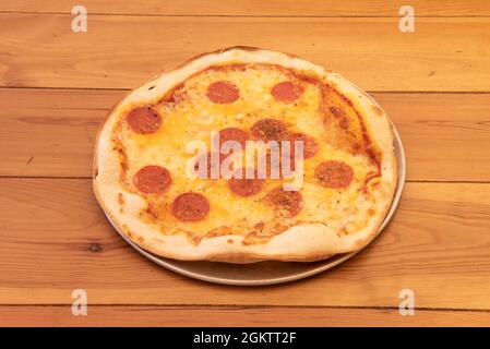 Einfache italienische Thin Crust Pizza mit viel würzigem Pepperoni auf Mozzarella Käse und viel Oregano Stockfoto