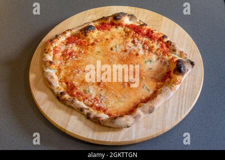 Kleine Pizza mit vier Käsesorten aus Weizenmehl auf grauem Hintergrund Stockfoto