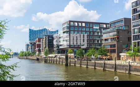 HAMBURG, DEUTSCHLAND - 8. Juni 2021 Panoramablick über den Grasbrookhafen mit Restaurants und Appartementhäusern mit Elbphilharmonie im Hintergrund Stockfoto