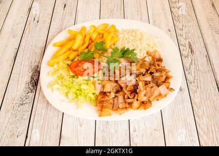 Kebab-Menü mit gegrilltem Hähnchenfleisch garniert mit gebratenen Kartoffeln, Basmati-Reis und Salat und Tomatensalat Stockfoto