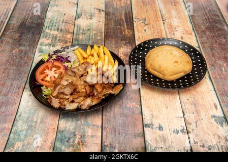 Toller Kebab-Teller mit einer Seite Chips und Salat und mit Pita-Brot auf der Seite Stockfoto