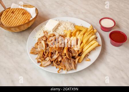 Menü Kebab-Teller mit Hühnerfleisch, Bratkartoffeln, frischem Käse und Basmati-Reis mit Pita-Brot und Saucen Stockfoto