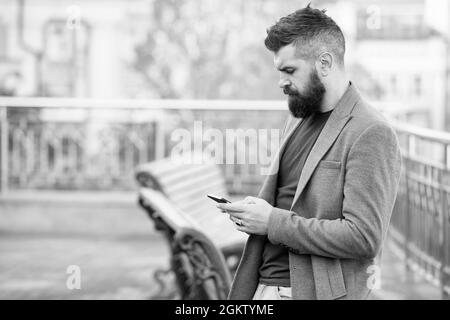 Vielbeschäftigter Hipster erhielt Nachricht per E-Mail im Smartphone über mobiles Internet im Freien, E-Mail Stockfoto