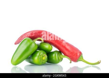 Eine Schote scharfem Rot und mehrere Schoten grünen Pfeffers, Nahaufnahme, isoliert auf Weiß. Stockfoto