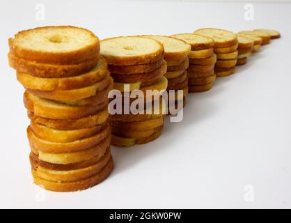 Brötchen backen. Runde gebackene Brotscheiben in einer Reihe angeordnet. Mini-Brotschips aus der Nähe. Stockfoto