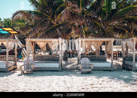 Leere Strandliegen mit Holzstühlen auf Sand im wunderschönen Strandresort Stockfoto