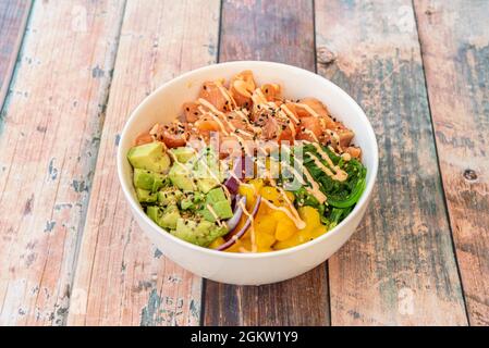 Lachs-Poke-Schale in weißer Schale auf hellem und dunklem Holztisch Stockfoto