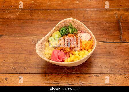 Schöne Präsentation einer Poke Schüssel mit mariniertem Lachs mit Mango und Ananas Tacos, reife Avocado, Wakame Seetang Salat, rote Zwiebel, in Scheiben geschnittenem Rettich Stockfoto