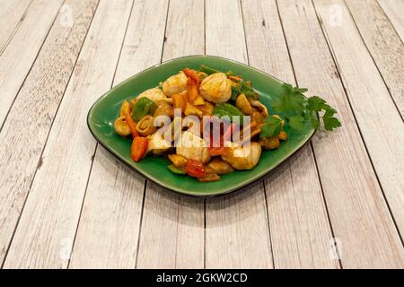 Thailändisches Chicken Curry Rezept mit Wok Sauteed Pilzen, Paprika und Zwiebeln und frischer Petersilie Stockfoto
