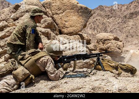 Eine US-Marine mit 2. Bataillon, 1. Marines, die an das Special Purpose Marine Air – Ground Task Force – Crisis Response – Central Command (SPMAGTF-CR-CC) 21.1 angeschlossen ist, feuert ein L7A2 General Purpose Machine Gun, während sie von einem Soldaten der britischen Armee mit 2. Bataillon, Fallschirmregiment, Jordanien, Juli 03, beobachtet wird, 2021. Die bilateralen Schulungen wurden durchgeführt, um die Beziehungen und die Zusammenarbeit zwischen den alliierten Kräften im CENTCOM-Befehlsgebiet zu stärken. SPMAGTF-CR-CC wurde entwickelt, um schnell und effizient auf eine Vielzahl von militärischen Operationen unter Einsatz von Luftfahrt-, Boden- und Logistikunternehmen zu reagieren Stockfoto