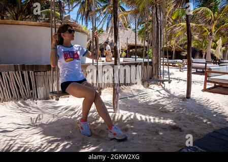 Wunderschöne Frau, die in einem wunderschönen mexikanischen Resort auf Schaukel sitzt Stockfoto