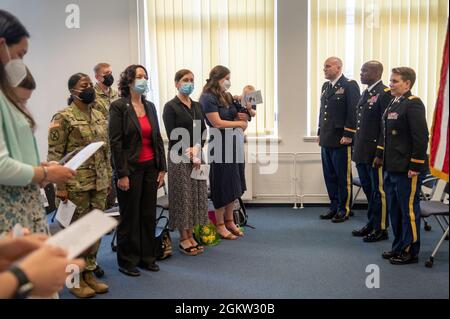 Publikum, Familienmitglieder und scheidender Direktor des 409. Theater Contracting Center der US Army, LTC Thomas R. Lutz (links), COL Freddy L. Adams II, Kommandant der 409. Contracting Support Brigade (Mitte) und LTC Alicia Burrows, angehender Direktor des 409. Theater Contracting Center (rechts), Bei der Verleihung des Direktorenwechsels in Kaiserslautern. Stockfoto