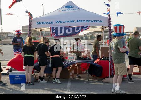 Während der Extravaganza am 4. Juli im Camp Arifjan, Kuwait, 4. Juli 2021, holen Servicemitarbeiter Hüfttaschen aus einem Zelt ab. Die Extravaganza wurde sowohl von den Organisationen Moral, Welfare and Recreation als auch United Service veranstaltet, die zusammenarbeiteten, um Spiele und Wettkämpfe sowohl in Camp Buehring als auch in Camp Arifjan zu bringen. Stockfoto