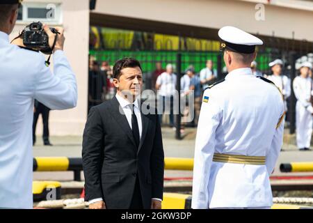 210704-N-BM428-0151 ODESA, Ukraine (4. Juli 2021) der ukrainische Präsident Wolodymyr Zelensky wird von einem ukrainischen Marineoffizier während der Zeremonie des ukrainischen Navy Day-Teils der Übung Sea Breeze 2021 in Odesa, Ukraine, am 4. Juli 2021 begrüßt. Übung Sea Breeze ist eine multinationale maritime Übung, die seit 1997 von der Sechsten Flotte der USA und der ukrainischen Marine veranstaltet wird. Sea Breeze 2021 soll die Interoperabilität der teilnehmenden Nationen verbessern und die Sicherheit und den Frieden im Seeverkehr in der Region stärken. Stockfoto