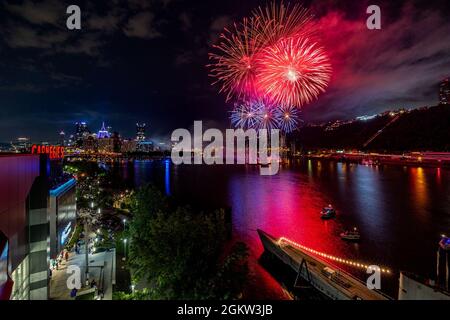 Ein Blick auf das Pittsburgh Feuerwerk vom Observatorium Balkon des Carnegie Science Center, 4. Juli 2021. Die Schleusen und Dämme des U.S. Army Corps of Engineers Pittsburgh District sind das ganze Jahr über geöffnet, auch an Bundesfeiertagen, für Freizeitboote, die die Aussicht auf die Stadt genießen können, und für kommerzielle Lastkähne, die sicher auf den Wasserstraßen navigieren können. Stockfoto