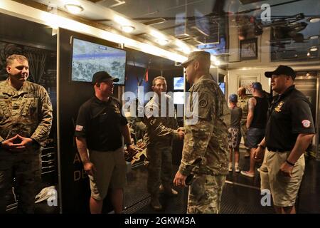 Brig. General Ernest Litynski, Center, Kommandierender General, 85. US Army Reserve Support Command, erhält eine Tour durch den U.S. Army Special Operations Display Trailer von Rekrutierern, die dem U.S. Army Recruiting Battalion-Milwaukee während des NASCar Cup Series-Rennens am 4. Juli in Road America, Elkhart Lake, Wisconsin, zugewiesen wurden, 4. Juli 2021. Litynski nahm als hochrangiger Anführer der Armee an dem Rennen Teil und schwor bei den Zeremonien vor dem Rennen 20 zukünftige Soldaten. Das Rekrutierungs-Bataillon der US-Armee und die Appleton Recruiting Company brachten Rekrutierer und Aussteller aus ihrem gesamten Gebiet zusammen, um sich mit ihnen zu treffen Stockfoto