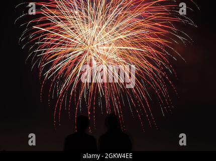 Mitglieder der Gemeinschaft beobachten das Feuerwerk auf dem Asphalt des Flugfeldes der Los Alamitos Army auf der Trainingsbasis der Joint Forces, Los Alamitos, Kalifornien, während der Drive-Up Feuerwerke am 4. Juli, die am 4. Juli 2021 spektakulär sind. Die 34. Jährliche Veranstaltung wird von der Basis ausgerichtet und von den benachbarten Städten Los Alamitos und Seal Beach präsentiert. Stockfoto