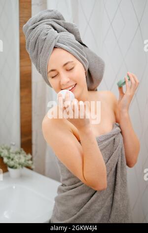Frau schnüffelt ein Glas Creme für die Jugend der Haut des Gesichts. Stockfoto