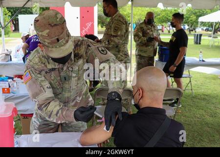 1. LT. Carlos Velázquez, ein Sanitäter der Puerto Rico State Guard, verabreicht einem Mann im „Parque Pasivo Las Croabas“ in Fajardo, Puerto Rico, einen Impfstoff gegen COVID-19, 4. Juli 2021. Um die maximale Anzahl von Personen zu erreichen, die gegen COVID-19 geimpft wurden, werden im Rahmen von ​​Operation Warp Speed Streikteams der PRNG verschiedenen Sektoren der Insel zugewiesen. Stockfoto