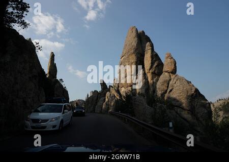 Autos fahren auf Needles Highway mit steilen Felsformationen neben in Custer State Park.Custer / Black Hills.South Dakota.USA Stockfoto