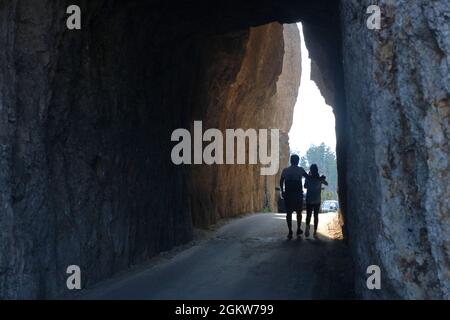 Menschen, die durch den Needles Eye Tunnel auf dem Needles Highway im Custer State Park wandern.Custer/Black Hills.South Dakota.USA Stockfoto