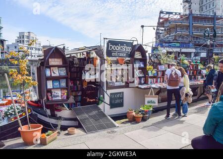 Die Menschen stöbern in den Büchern im schwimmenden Buchladen „The Word on the Water“ am Regent's Canal in „King's Cross“. London, Großbritannien. April 2021. Stockfoto