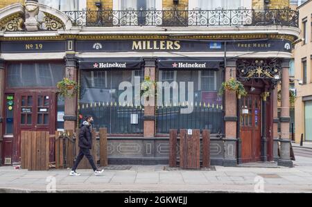 Ein Mann, der eine Gesichtsmaske trägt, geht während der Coronavirus-Sperre an einem geschlossenen Pub im Zentrum von London vorbei. London, Großbritannien, 10. Februar 2021. Stockfoto