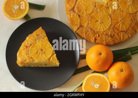 Scheibe selbstgebackenen Orange umgedrehten Kuchen mit orangefarbenen Scheiben auf der Oberseite. Aufgenommen auf weißem Hintergrund. Stockfoto