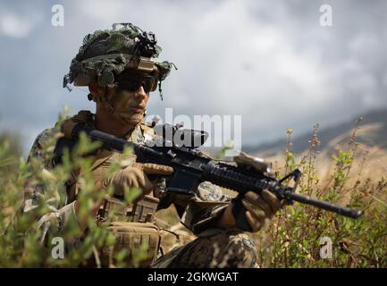 U.S. Marine Corps Lance CPL. Nichola Berserker, ein Sturmmann mit 1. Bataillon, 3d Marines, 3D Marine Division, sorgt für Sicherheit während eines Luftangriffs auf das Marine Corps Training Area Bellows, 9. Juli 2021. Die Ausbildung stärkte die Kompetenz des Bataillons im städtischen Betrieb und zeigte gleichzeitig ihre Fähigkeit, wichtiges maritimes Gelände schnell zu ergreifen und zu verteidigen. 1/3 trainiert nach Force Design 2030 zum ersten Littoral Combat Team. Stockfoto