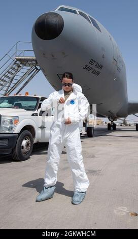 Der Kapitän der US-Luftwaffe Erin Walsh, 380. Expeditionary Aircraft Maintenance Squadron Officer und verantwortlich für die KC-10 Extender, gibt sich eine Schutzsuite, bevor er lernt, wie man die Toilette eines Extenders auf dem Luftwaffenstützpunkt Al Dhafra, Vereinigte Arabische Emirate, warten kann, 9. Juli 2021. Walsh, deren Erfahrung bisher auf Kampfflugzeuge beschränkt war, lernt, die Toilette des Extenders zu warten, um zu verstehen und zu schätzen, was ihre Betreuer durchmachen, um die Mission zu erfüllen. Stockfoto