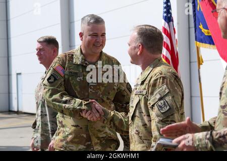 North Carolina National Guardsmen Chief Warrant Officer 4 Christopher Wilson (rechts) und Chief Warrant Officer 4 Daniel Piland von der 449. Combat Aviation Brigade gratulieren einander, nachdem er während einer Zeremonie in Morrisville, N.C., am 10. Juli 2021 zum Chief Warrant Officer 5 befördert wurde. Der General der NCNG Adjutant, Maj. Gen. Todd Hunt, gab die Zeremonie zur Beförderung ab, um Wilson und Piland zu ihren Leistungen und ihrem Engagement für die NCNG zu gratulieren. Stockfoto