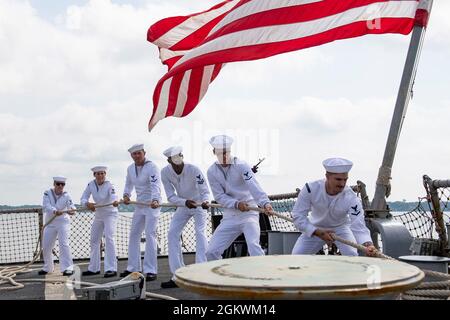 YORKTOWN, Virginia (11. Juli 2021) – Matrosen, die dem Lenkflugkörper-Zerstörer USS Laboon (DDG 58) der Arleigh Burke-Klasse zugewiesen wurden, übernehmen die Anlegestellen, während Laboon nach einem 7-monatigen Einsatz im Einsatzgebiet der Fünften und Sechsten Flotte der USA am 11. Juli 2021 in den Heimathafen zurückkehrt. Laboon ist eine Pier-Seite in der Naval Weapons Station Yorktown, die Routingwartung durchführt. Stockfoto