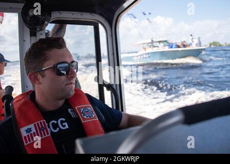 Coast Guard Petty Officer 3rd Class Gage Hunnicutt, ein Maschinist, scannt die Wasserstraße während der Stanley Cup Championship Boat Parade von Tampa Bay Lightning, Tampa, Florida, 12. Juli 2021. Die Küstenwache arbeitete mit ihren interagenturischen Partnern an der Patrouille zusammen, um Sicherheit zu gewährleisten, die Bewegung der Schiffe in der Parade zu gewährleisten und die Bootfahrt während der Feier sicher zu halten. Stockfoto