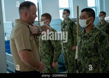 Aviation Boatswain’s Mate (Handling) 1st Class Benjamin Smith, ein Rekrut Division Commander, korrigiert einen rekrutenführer während des Bohrens in einem Abteil der USS Hopper Rekrutenbaracke beim Recruit Training Command. Mehr als 40,000 Rekruten trainieren jährlich im einzigen Bootcamp der Marine. Stockfoto