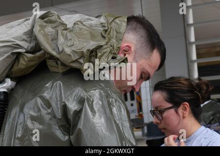 Maj. Tyler Cody, Allgemeinzahnarzt der 59. Dental Group, gibt während der Übung „Ready EAGLE“ in der Joint Base San Antonio-Lackland, Texas, am 13. Juli 2021 persönliche Schutzausrüstung ab. Flugleute des 59. Medizinischen Flügels üben das Anziehen und Abtragen von PSA zur Beurteilung der aktuellen Ansprechbarkeit. Stockfoto