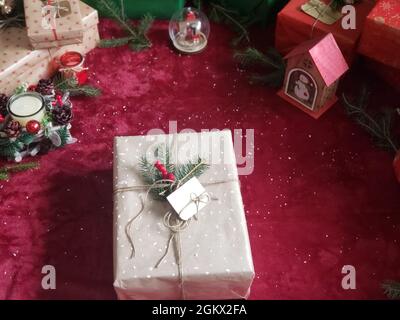 Rustikale Retro Geschenke, Geschenkboxen auf rotem Hintergrund. Weihnachtszeit Stockfoto