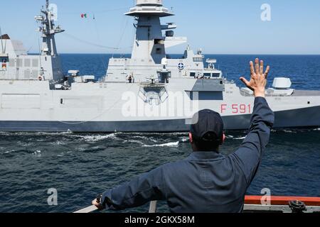 SCHWARZES MEER (15. Juli 2021) Cmdr. John D. John, kommandierender Offizier des Arleigh Burke-Klasse-Lenkraketen-Zerstörers USS Ross (DDG 71), winkt der Besatzung an Bord der italienischen Fregatte Virginio Fasan (F 591) zu, während sie während der von Bulgarien geführten Übung Breeze, 15. Juli 2021, Auffüllungsübungen auf See im Schwarzen Meer durchführen. Ross, der im spanischen Rota stationiert ist, ist auf Patrouille im Einsatzgebiet der Sechsten Flotte der USA, um regionale Verbündete und Partner sowie nationale Sicherheitsinteressen der USA in Europa und Afrika zu unterstützen. Stockfoto