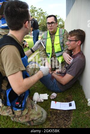 Der Senior Airman der US-Luftwaffe, Braden Underwood, ein medizinischer Techniker der 81st Healthcare Operations Squadron und Master Sgt. Lawrence Whitmore, 81st Operational Medicine Readiness Squadron Medical Technician, wendet Triage auf Airman 1st Class an Robert Langhi, 81st Medical Support Squadron Student, während er ein verletzte Opfer während einer 81st Medical Group Functional Exercise hinter dem Keesler Medical Center auf der Keesler Air Force Base, Mississippi, 15. Juli 2021 porträtiert. Das Szenario beinhaltete eine Explosion von Chlorflaschen, die bei mehreren Opfern Verbrennungen und andere Verletzungen verursachte. Die Massenverletzte übt Stockfoto