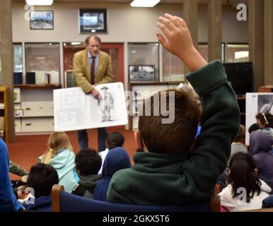 Ein Kind vom Porter Youth Center hebt die Hand, als Cameron Binkley, Befehlshistoriker, Defense Language Institute Foreign Language Center, mit Kindern im Brig spricht. General Harry Dwight Chamberlin Library, Ord Military Community, Kalifornien, Juli 15. Stockfoto