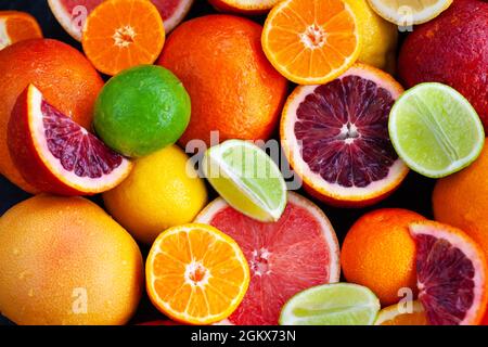Nahaufnahme von frischen, saftigen Zitrusfrüchten - Orangen, Mandarinen, Zitronen und Limetten, Draufsicht Stockfoto