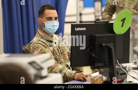 US Army Staff Sgt. Jonathan Londono, 3. Bataillon, 112. Feldartillerie, 44. Infanteriebrigade Combat Team, überprüft eine Liste der Patienten beim Morris COVID-19 Impfmegasite in Rockaway, N.J., 16. Juli 2021. Mitarbeiter der Nationalgarde von New Jersey haben im Juli 16-18 Operationen in den Grafschaften Morris, Gloucester und Burlington zur Unterstützung der staatlichen Impfmission abgeschlossen. Mehr als 500 Soldaten und Luftmänner unterstützten staatliche und lokale Gesundheitshelfer und Ersthelfer während der 16 Monate ihres Betriebs und sicherten die Verteilung von mehr als zwei Millionen COVID-19-Impfstoffdosen. Stockfoto