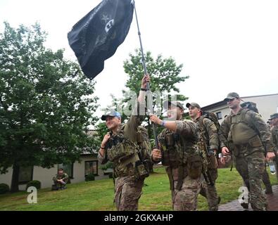 US Air Force Airmen, die dem 786. Explosive Ordnance Disposal Flight zugewiesen wurden, halten während des 6. Jährlichen Chief Master Sgt eine Flagge hoch. Der Air Force Paul Airey Memorial Ruck auf dem Ramstein Air Base, Deutschland, 16. Juli 2021. Mehr als 100 Luftmänner, Zivilisten und Familienmitglieder nahmen an dem Ruck Teil, an den Airey für seine Widerstandsfähigkeit während seiner Zeit als Kriegsgefangener und sein Engagement für die Luftwaffe der US-Luftwaffe erinnert wurde. Stockfoto