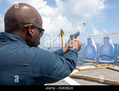 EAST CHINA SEA (16. Juli 2021) Fire Controlman Firecontrolman 3rd Class Robert Hollins, aus Los Angeles, ca., feuert während eines Kleinwaffeneinspielungskurses auf dem Flugdeck an Bord des Arleigh Burke-Klasse Lenkraketen-Zerstörers USS John S. McCain (DDG 56) eine M9-Pistole ab. McCain ist der Task Force 71/Destroyer Squadron (DESRON) 15 zugeordnet, der größten DESRON der Marine und der wichtigsten Surface Force der US-Flotte der 7. Flotte. Stockfoto