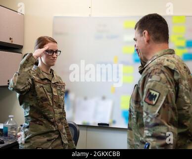 US Air Force Staff Sgt. Alexandra Olesen, links, 133. Sicherheitsbüro, begrüßt LT. General Michael A. Loh, Direktor, Air National Guard, nachdem er seine Münze in St. Paul, Minnesota, am 17. Juli 2021 erhalten hatte. Olesen wurde von ihrer Führung als herausragende Performerin für den 133. Airlift Wing, Wing Headquarters, anerkannt. Stockfoto